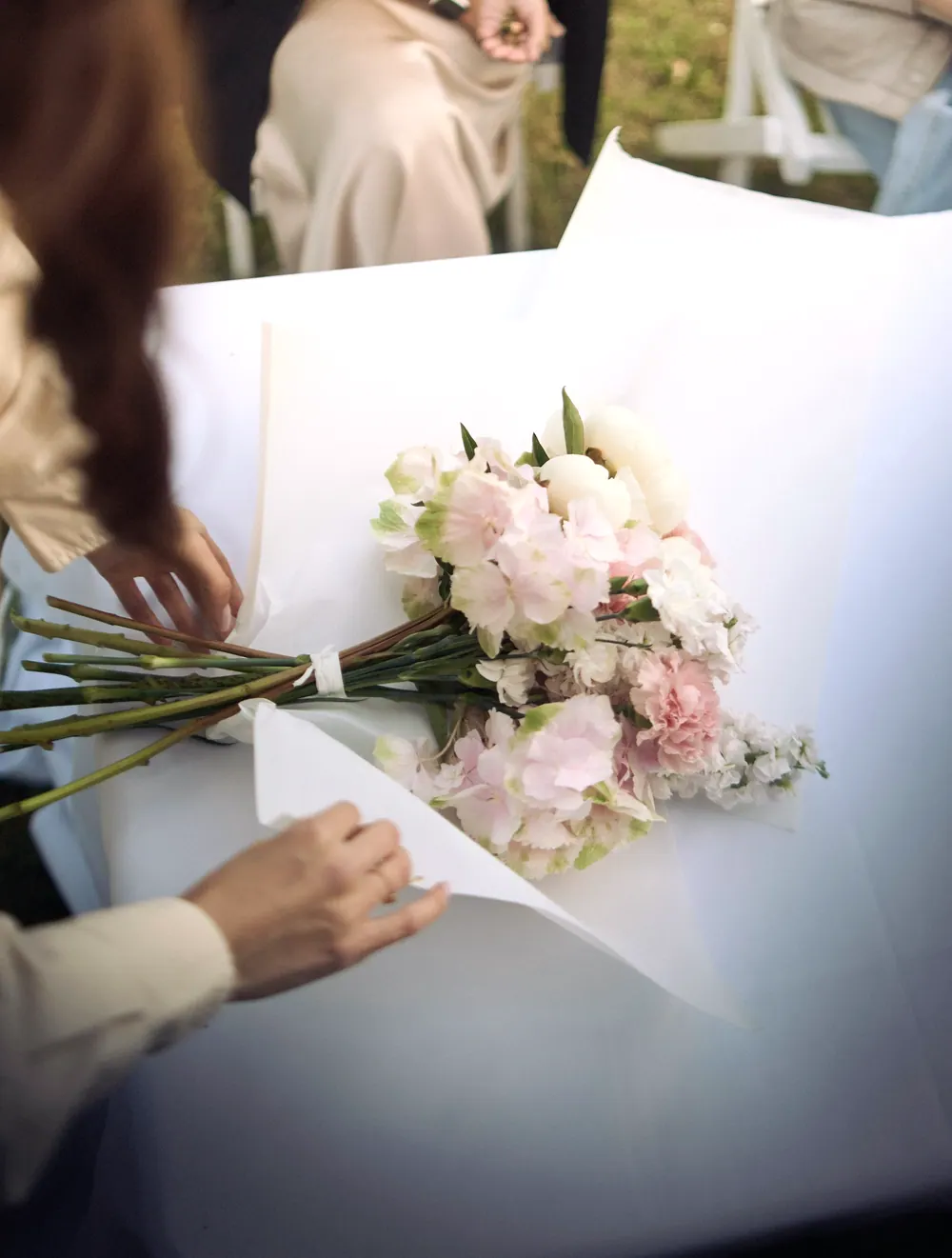 Manos de la florista acomodando flores sueltas sobre la mesa de trabajo