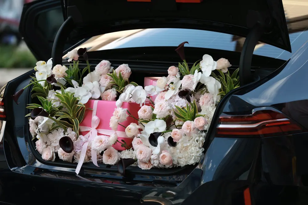 Cajas de flores listas en la cajuela del auto de reparto