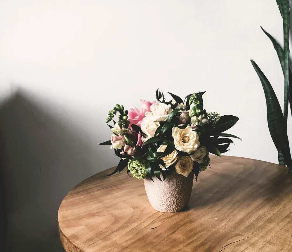 Arreglo de rosas y follaje sobre una mesa, listo para la oficina